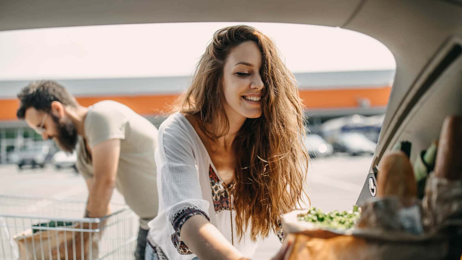 Woman with long hair picking up curbside grocery order.