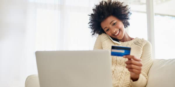 Woman on phone and laptop with credit card: How to Gain eCommerce Customers
