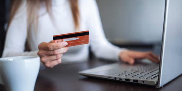 Woman ordering on laptop with credit card: Optimizing Digital Customer Experiences