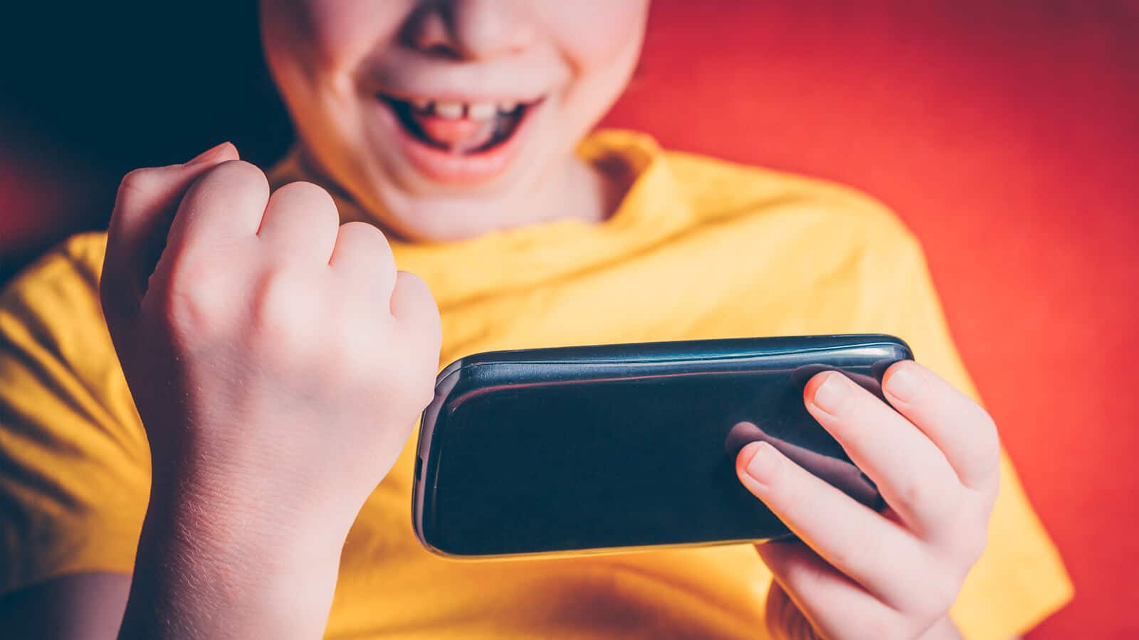 Happy child playing video game on mobile device