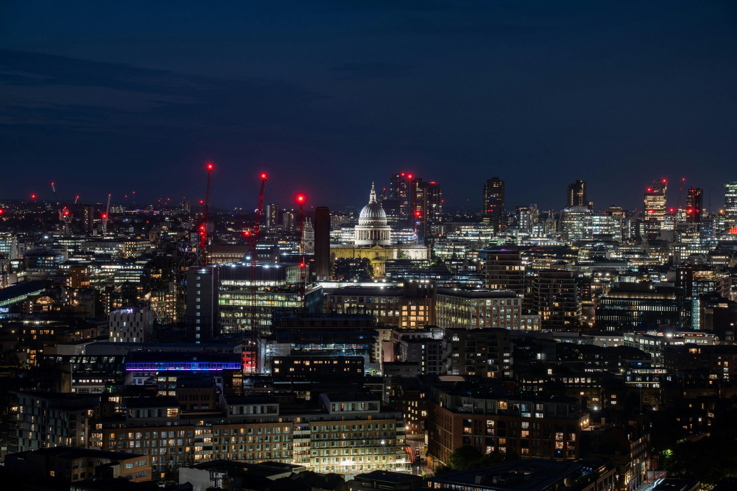Photo taken at night showing St Paul's Cathedral in the City of London surrounded by modern buildings.